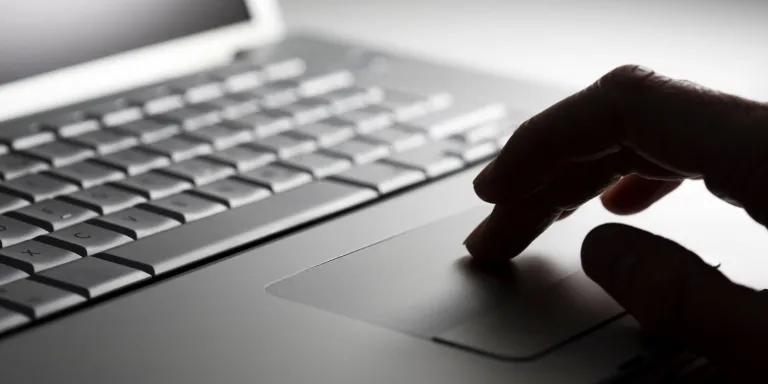 Hand using track pad on a laptop