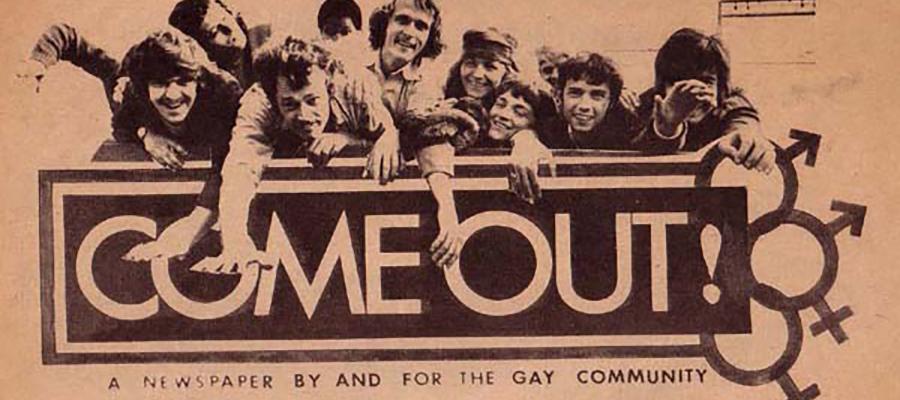 A group of men lean over a sign saying come out