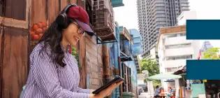 A student listens in to an online lecture on a tablet using headphones