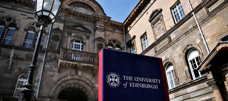 A sign for the University of Edinburgh beside a Victorian lamp in Elsie Inglis Quad in the Old Medical School.
