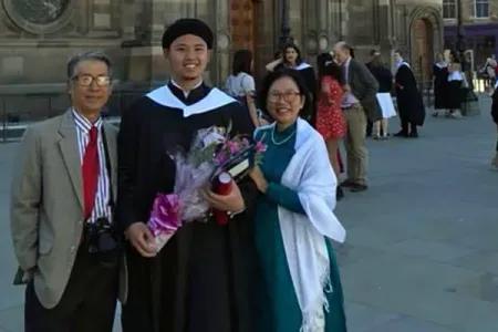 Mai poses in graduation robes with his family