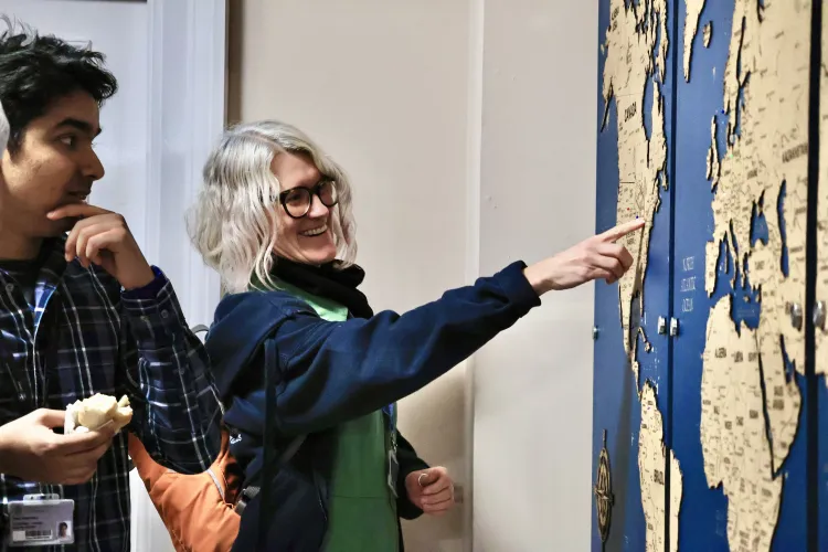 A male student and female member of staff discuss the map