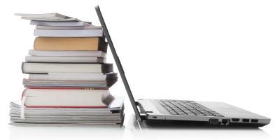 Laptop next to stack of books