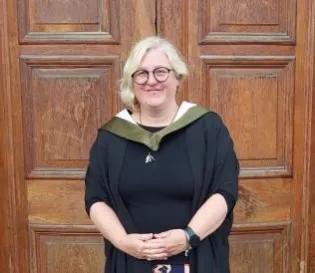 Student standing in graduating robes