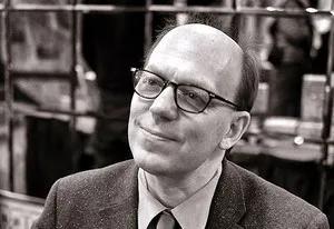 Greg Grandin wears glasses and a suit, and smiles warmly in this black-and-white image.