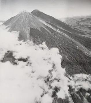 Black and white image of clouds over mountains